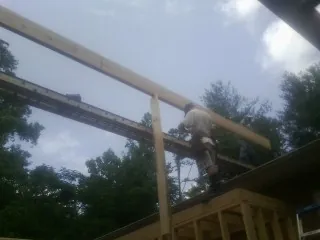 Carpenter setting a ridge beam over a new addition frame — Ice Dam Removal by Roofing Brothers in Timberlake