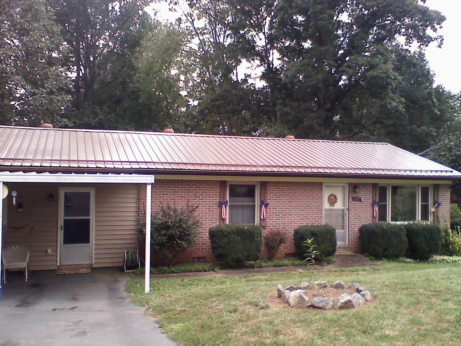 Bronze metal roof and carport on a brick ranch home — Roof Repair work by our crew in Timberlake